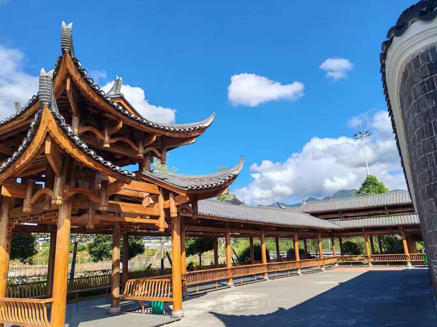 湘西旱码头土司府景区内木构长廊实拍，飞檐翘角与远山云影