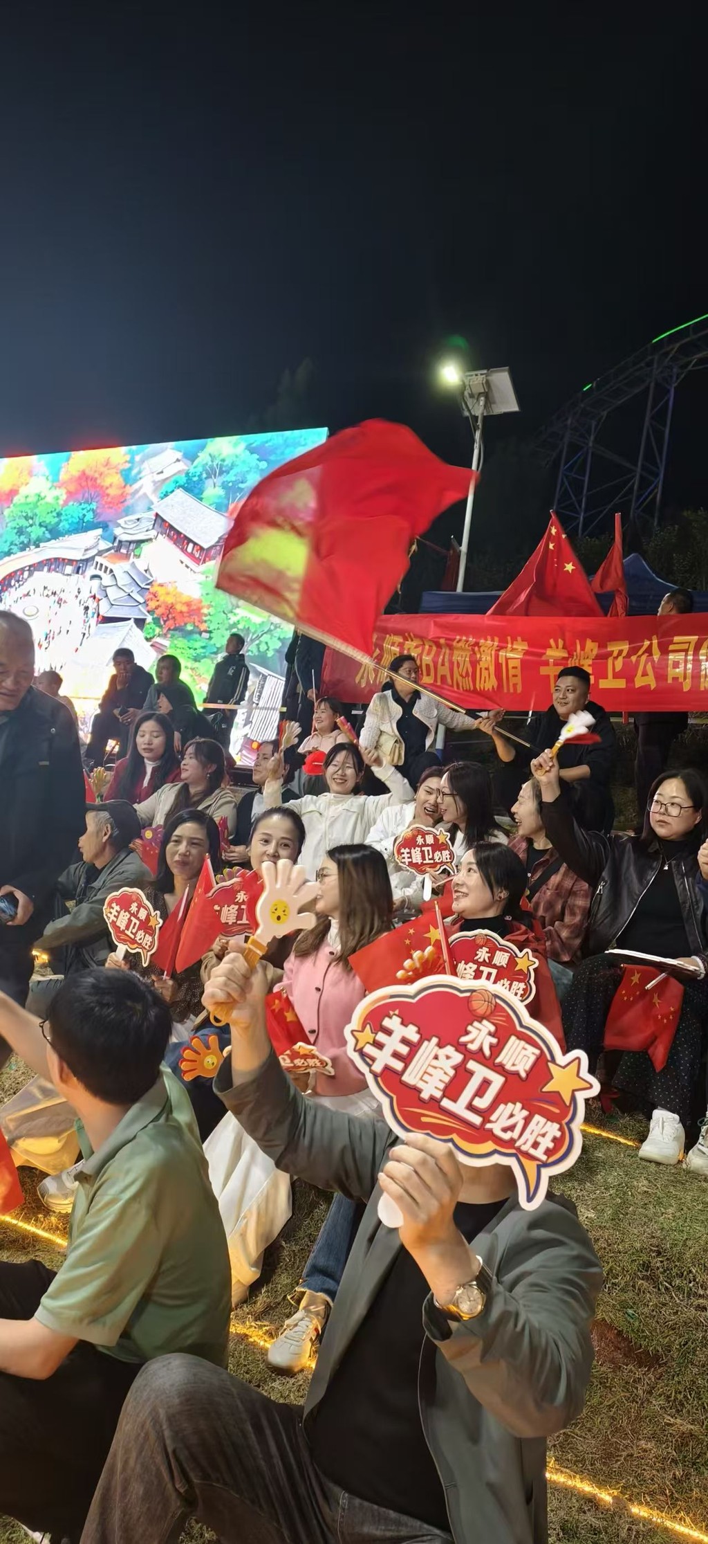 夜里灯从球场四角打下来,前两排照得清楚,后面的就是黑的山影